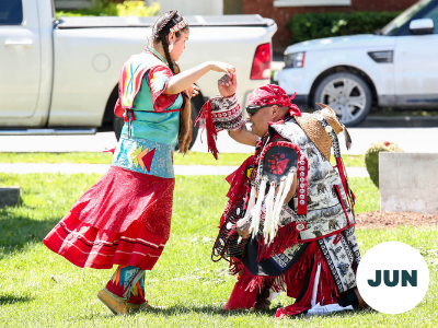 Two people dancing in ceremonial indigenous wear